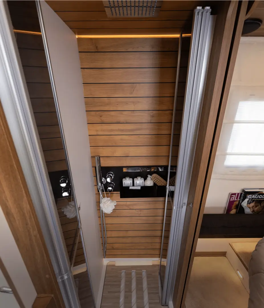 L’interno di un camper con le pareti in legno, il mobile e la porta del bagno.