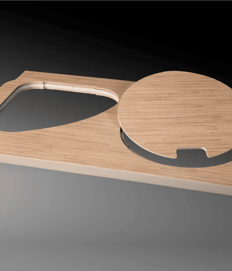 Un piano tavolo in legno con un incavo e un disco tondo, su fondo scuro.